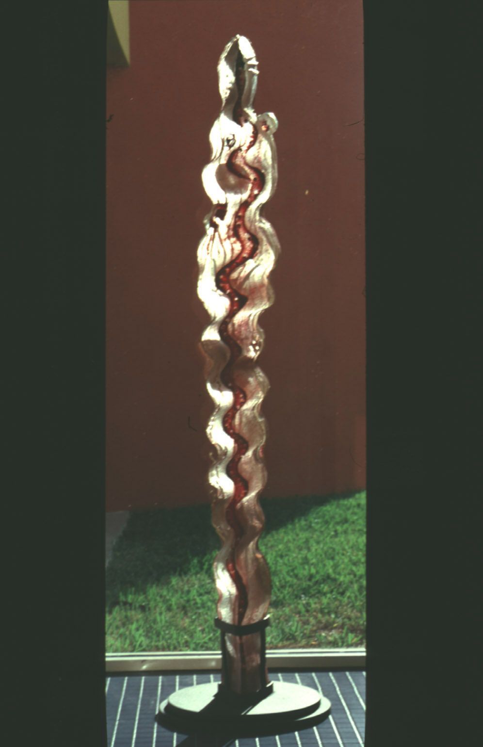 A statue of a woman is sitting on a table in front of a window