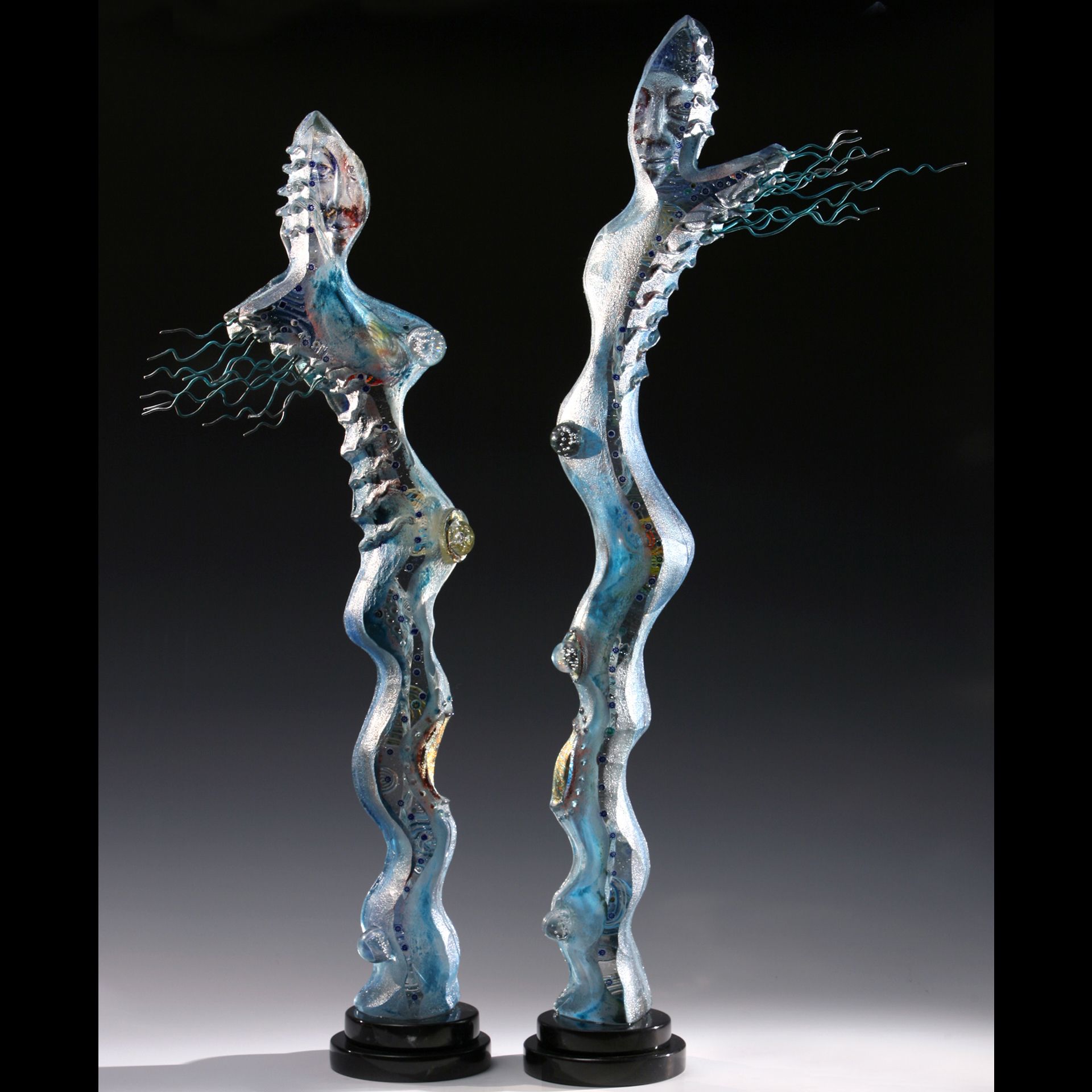 Two sculptures of a woman standing next to each other