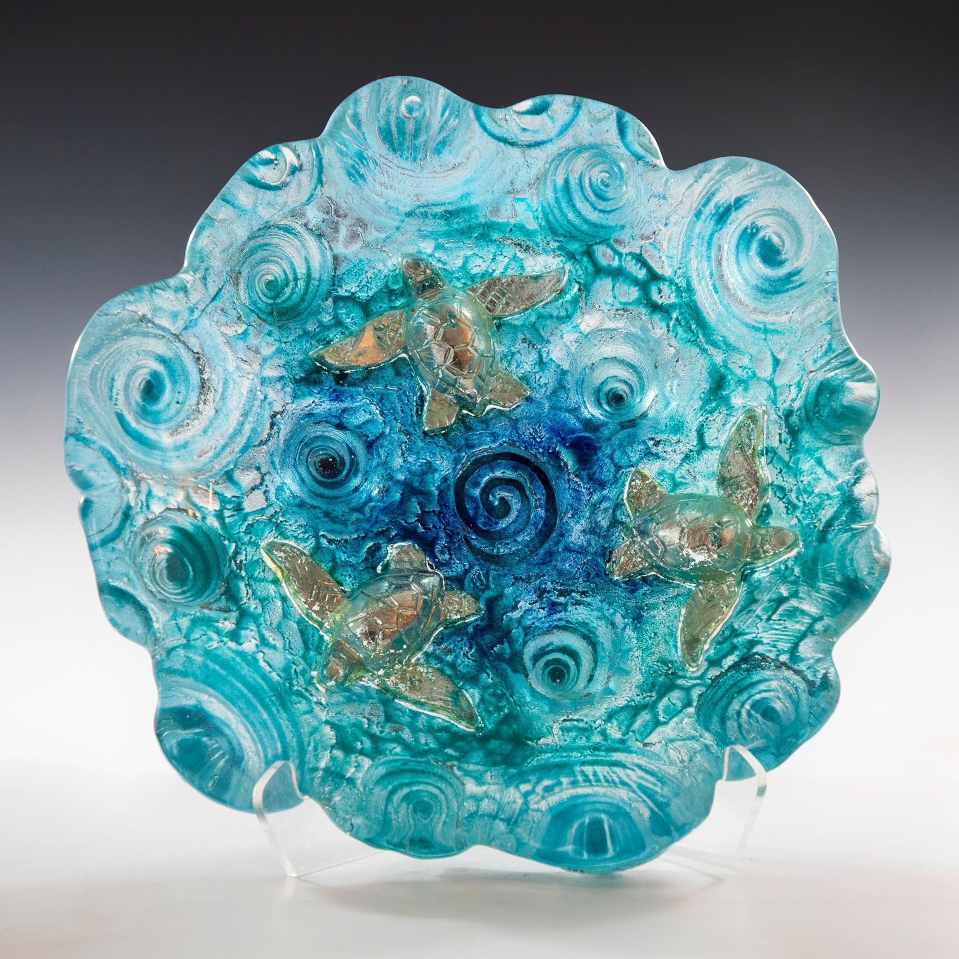 A blue plate with swirls on it is on a stand