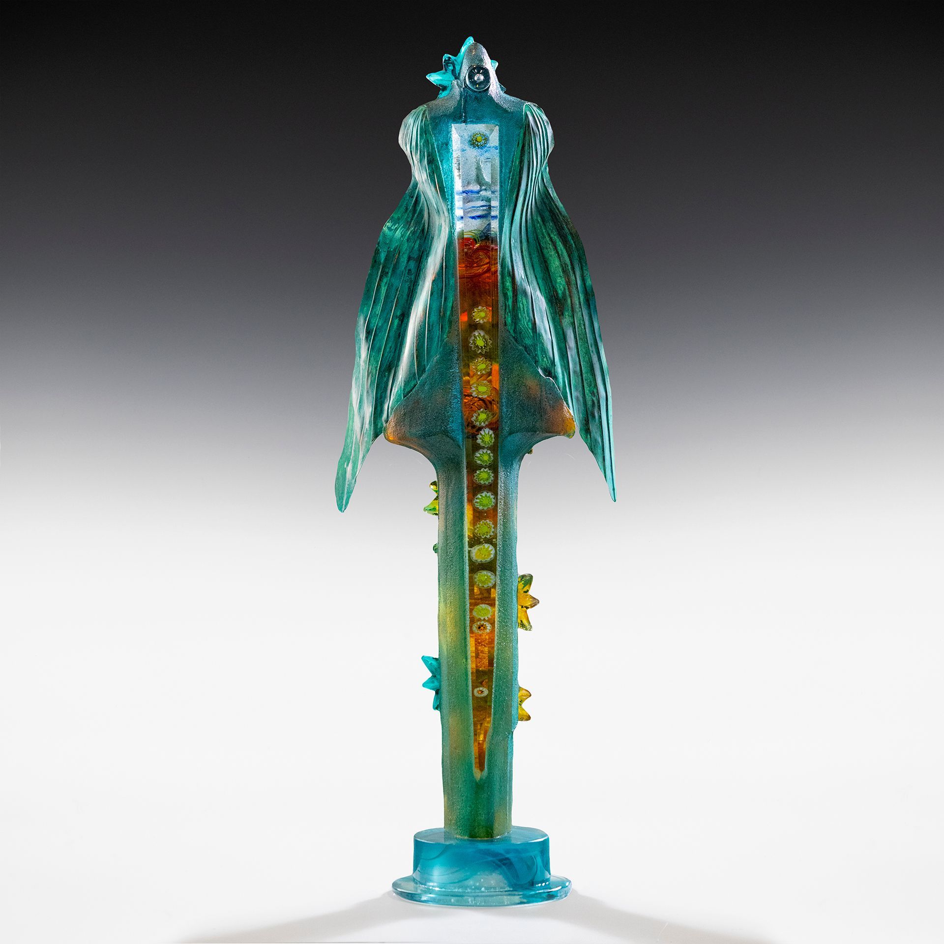 A statue of a bird is sitting on a white surface