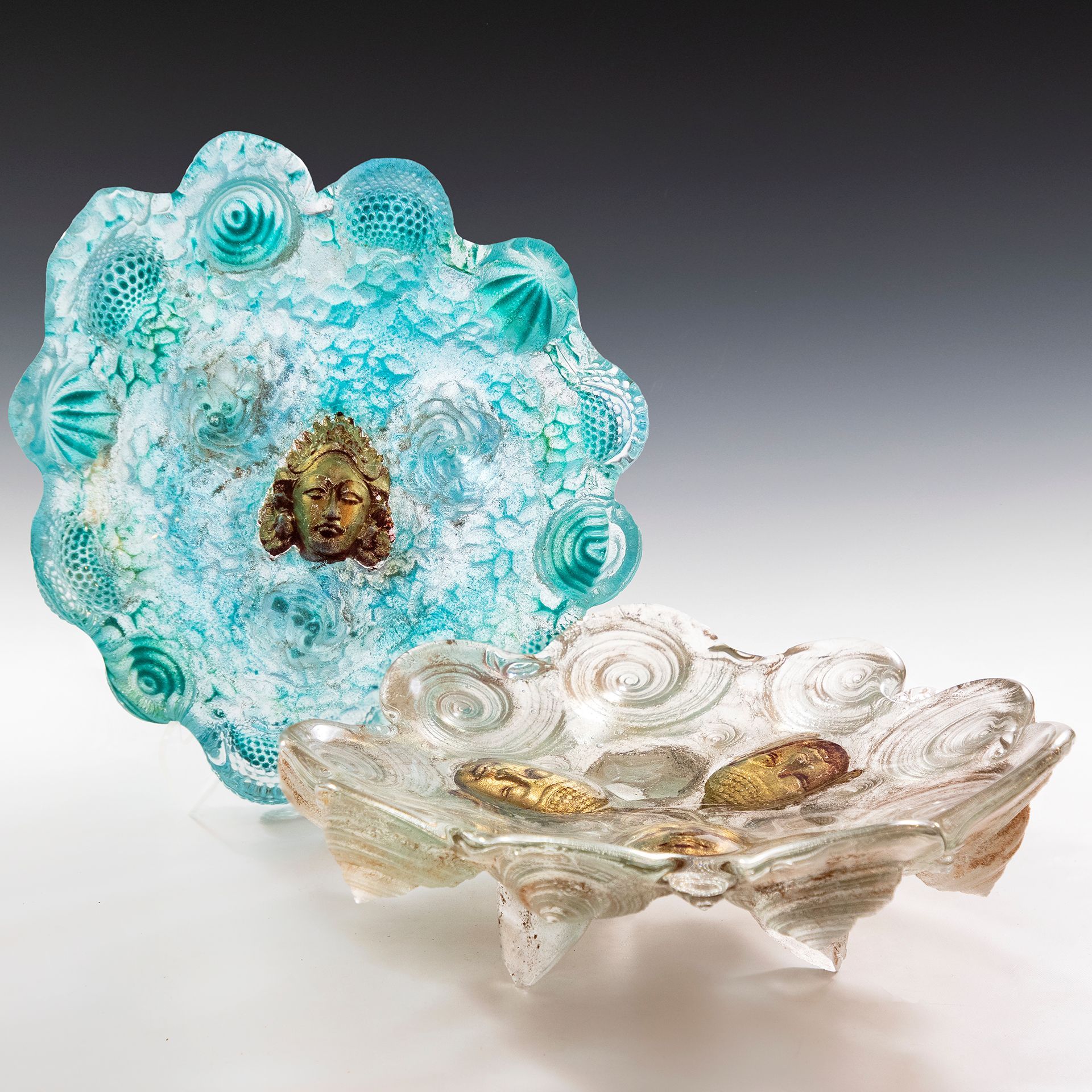 A blue and clear glass plate with a face on it