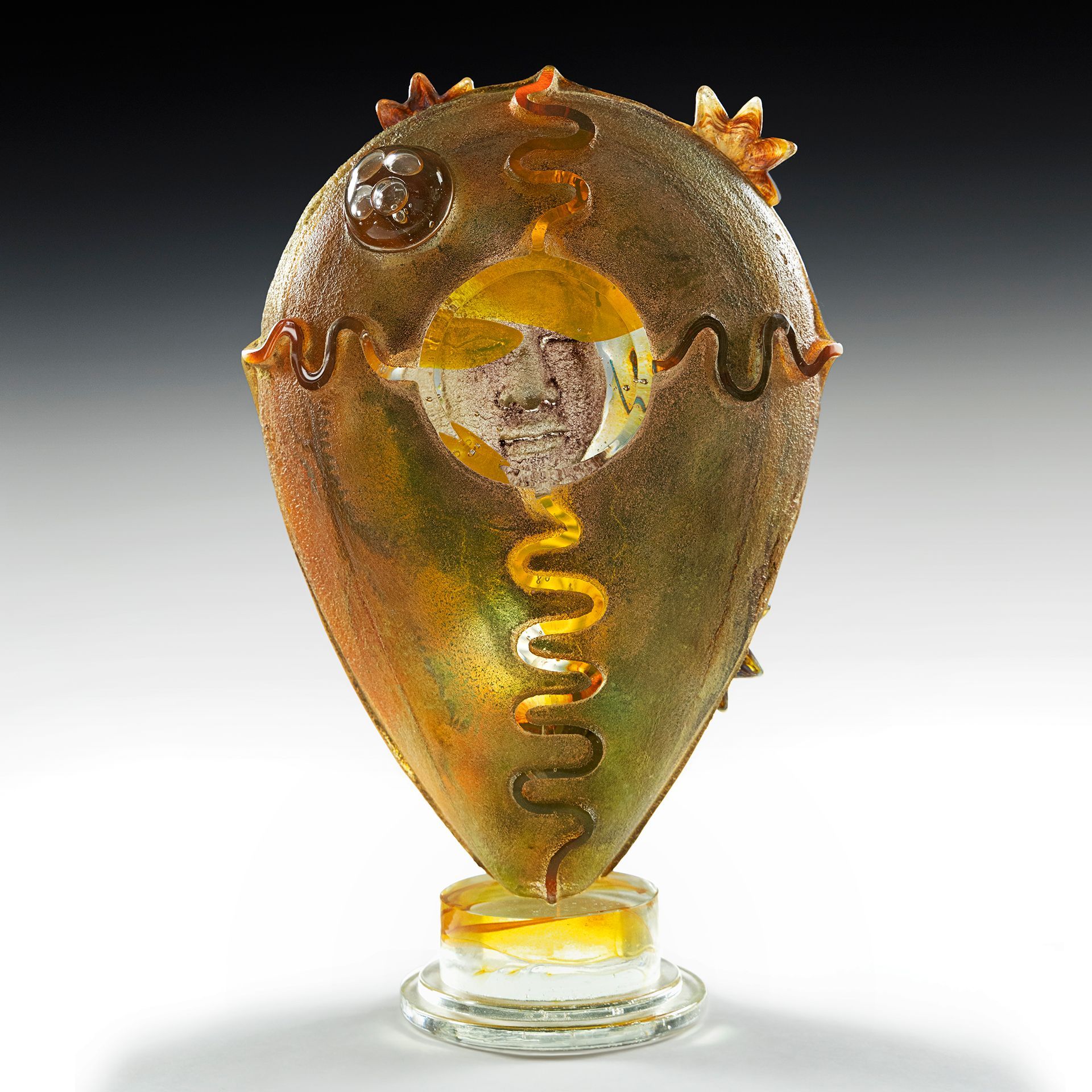 A glass sculpture with a snake design on it