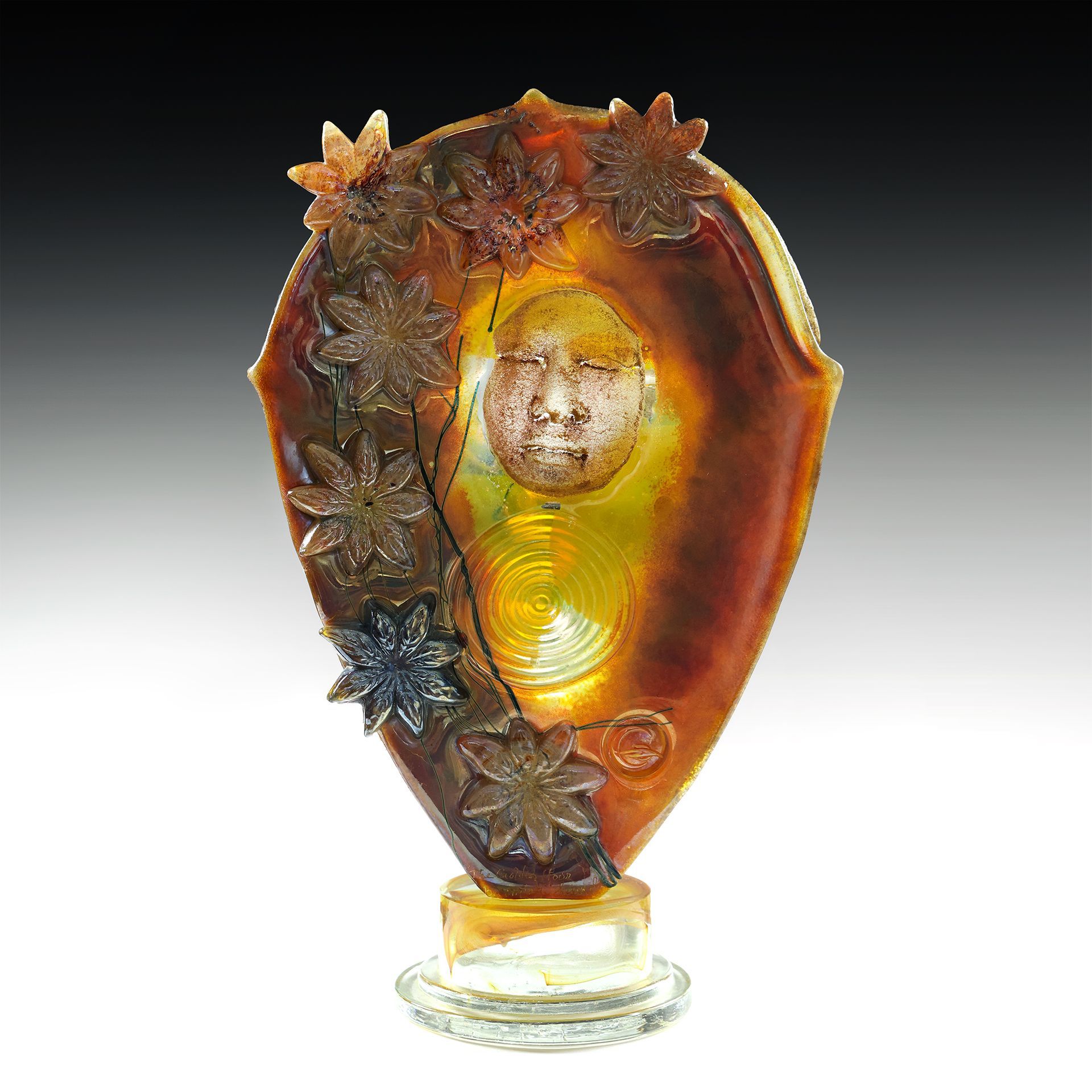 A sculpture of a face with flowers on it