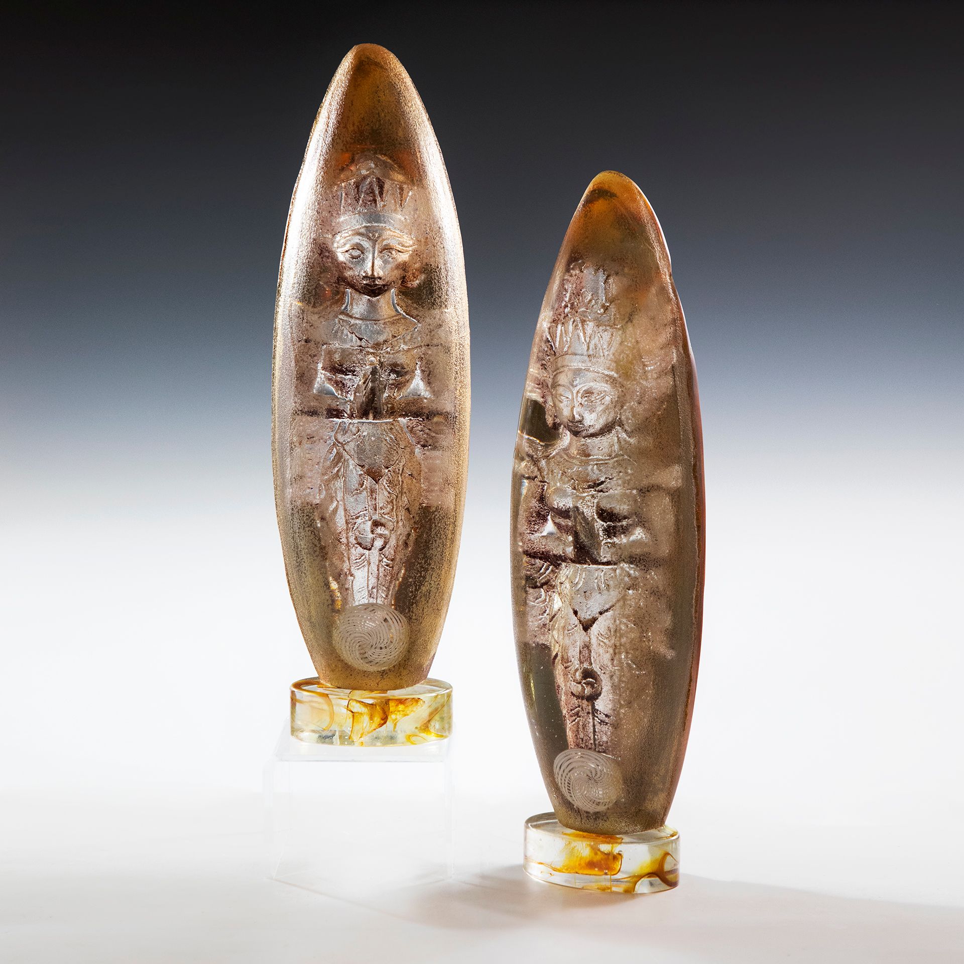 Two sculptures are sitting on a white surface