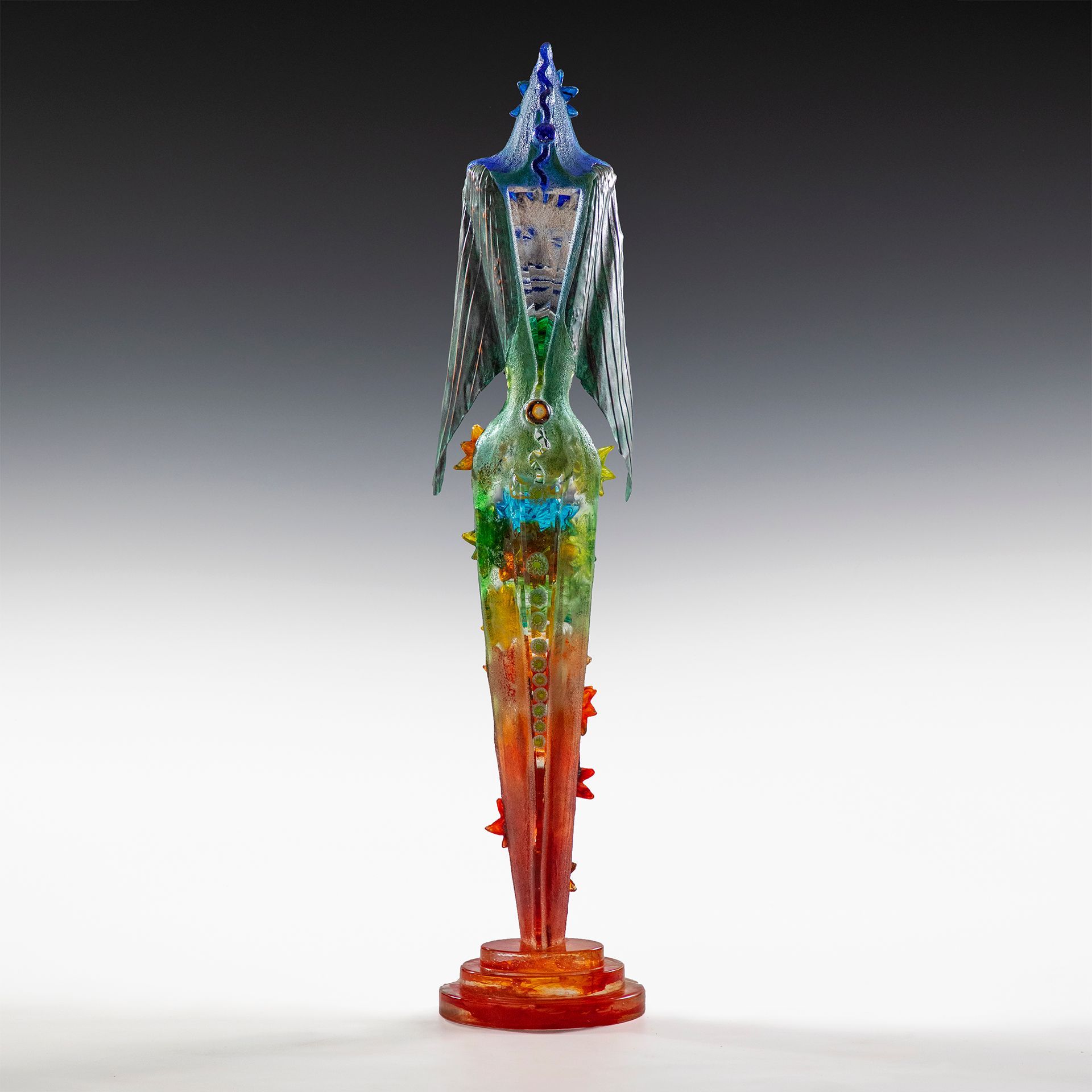 A colorful statue of a person with wings on a stand