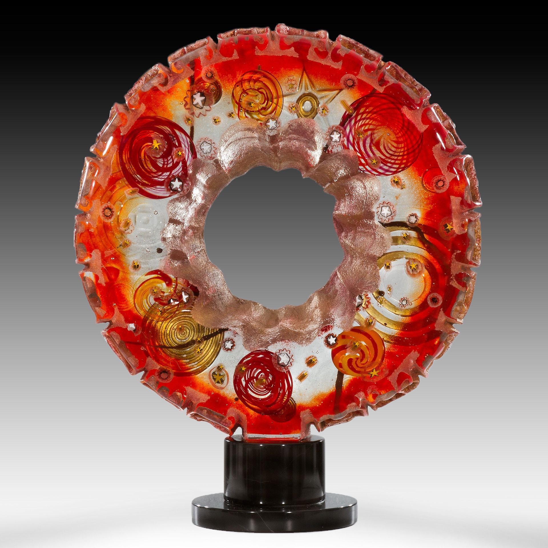 A red and white glass sculpture with a hole in the middle