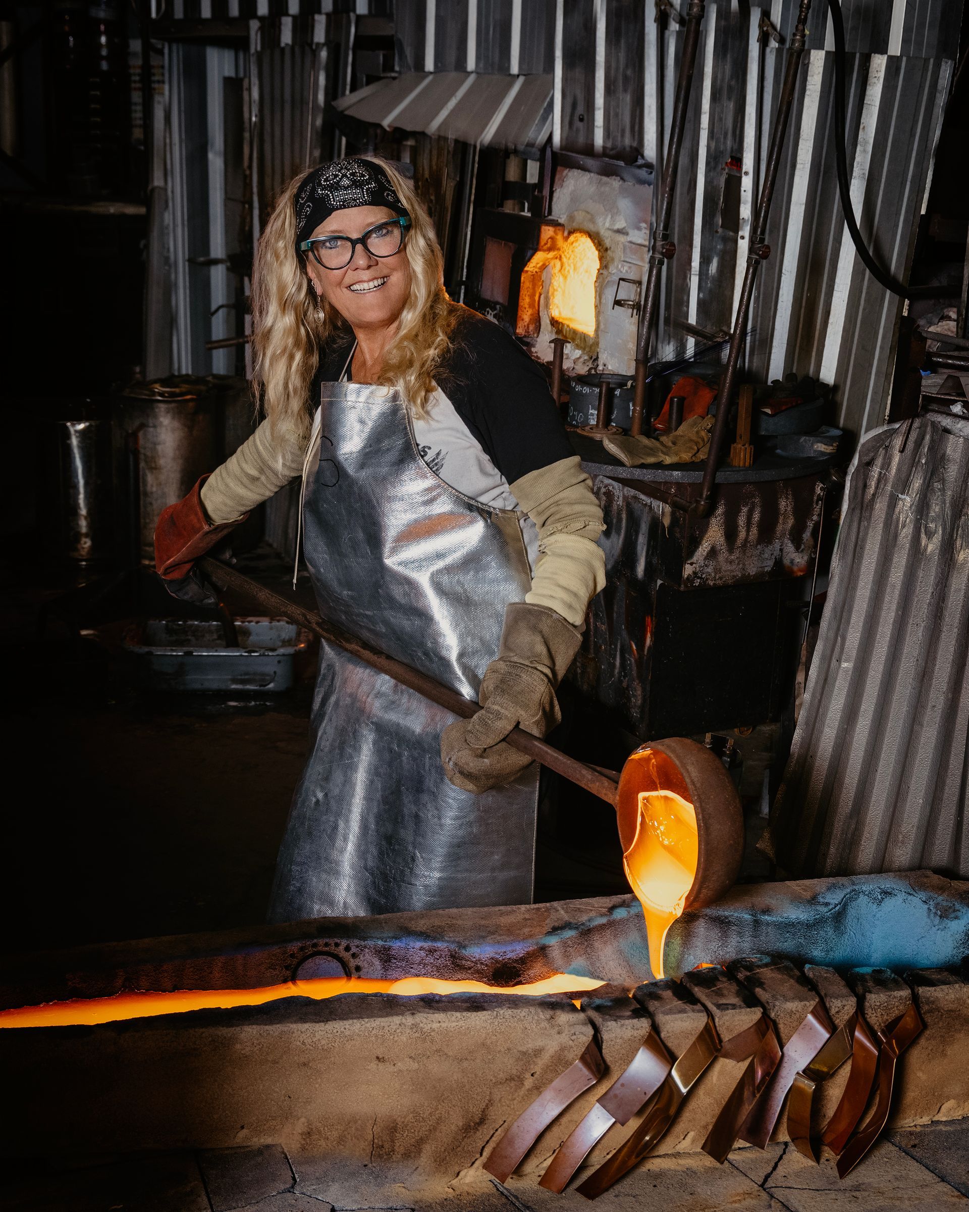 A woman is pouring molten metal into a furnace