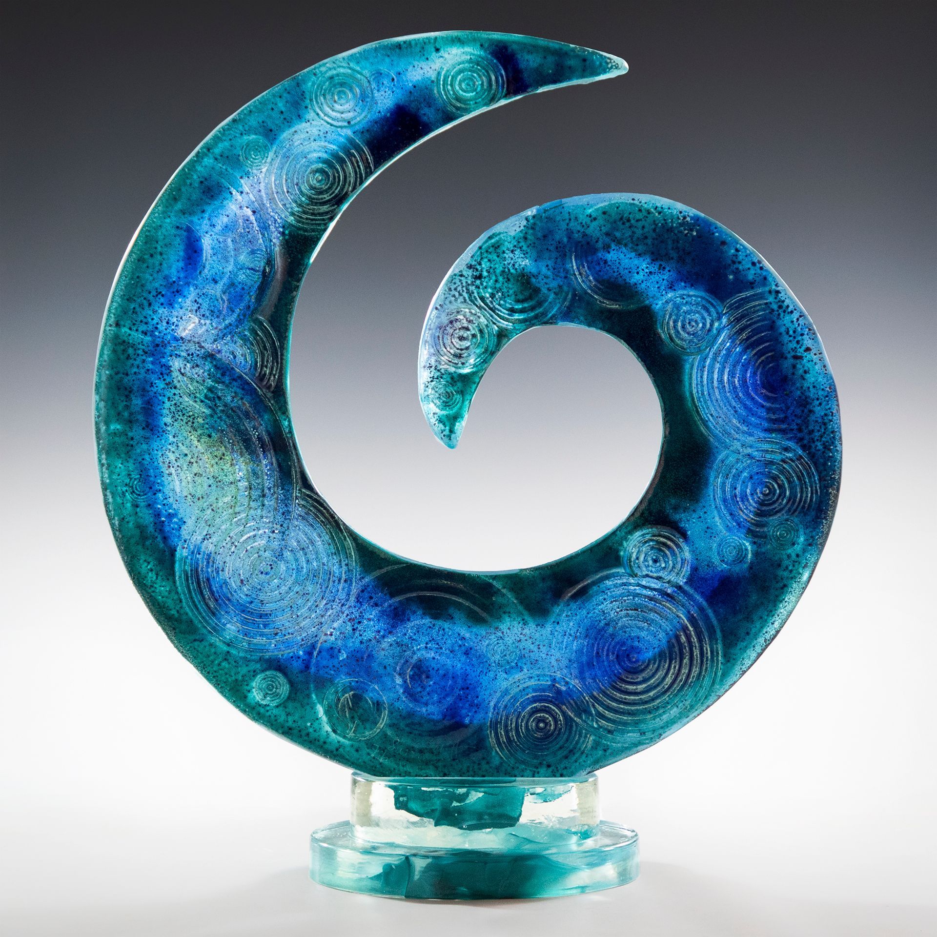 A blue glass sculpture of a spiral on a stand