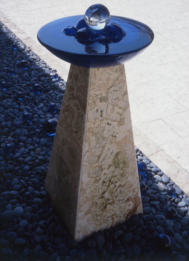 A blue bowl with a glass ball on top of it