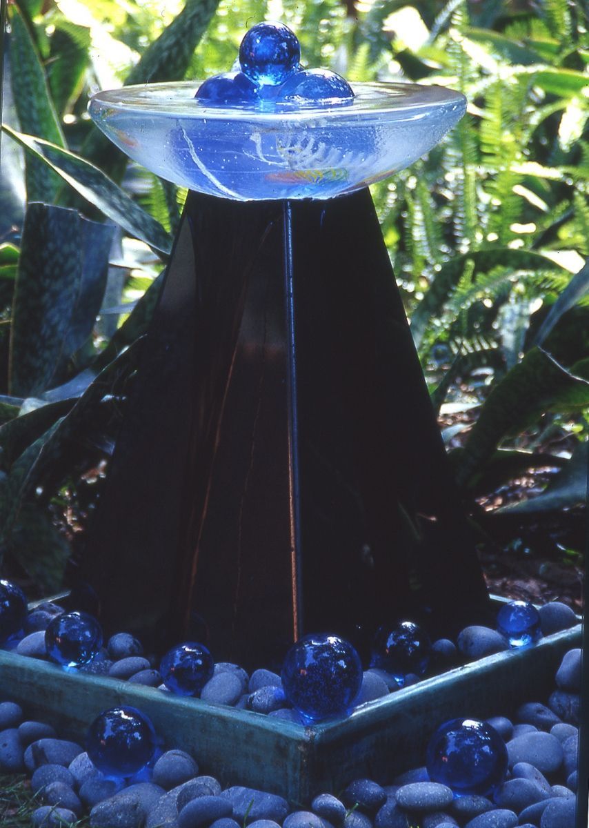 A fountain with blue glass balls on top of it