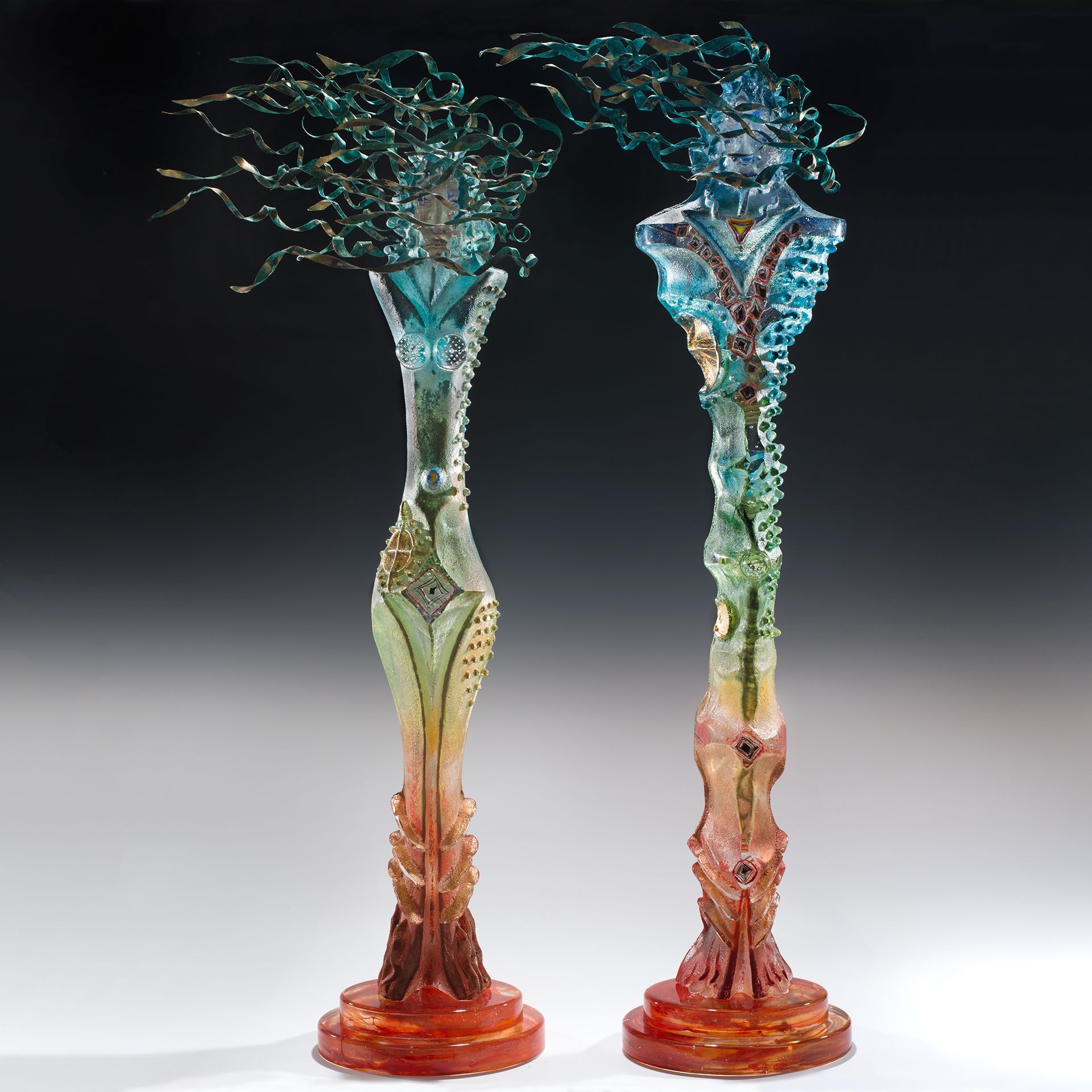 Two sculptures of a woman standing next to each other