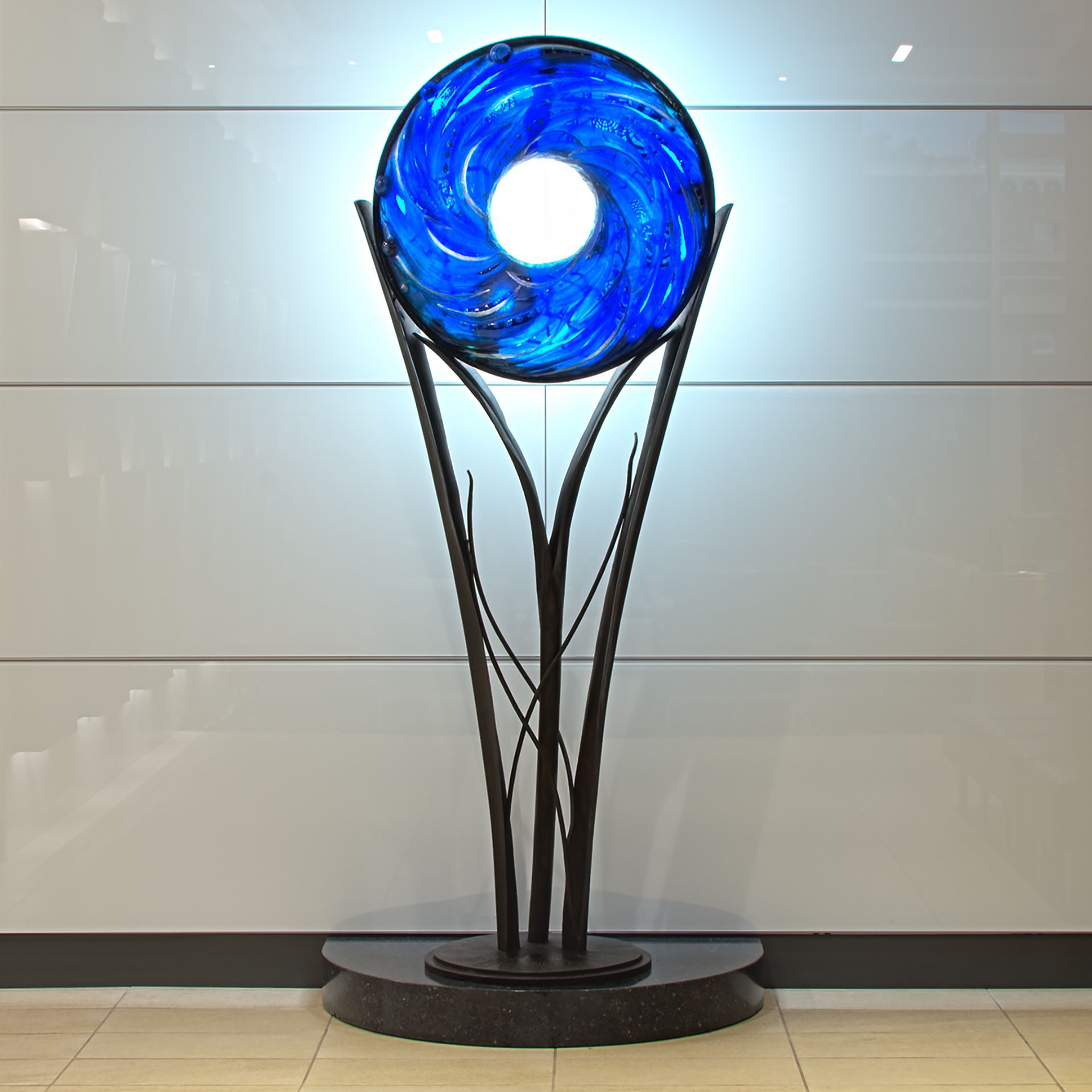 A blue glass sculpture with a light inside of it