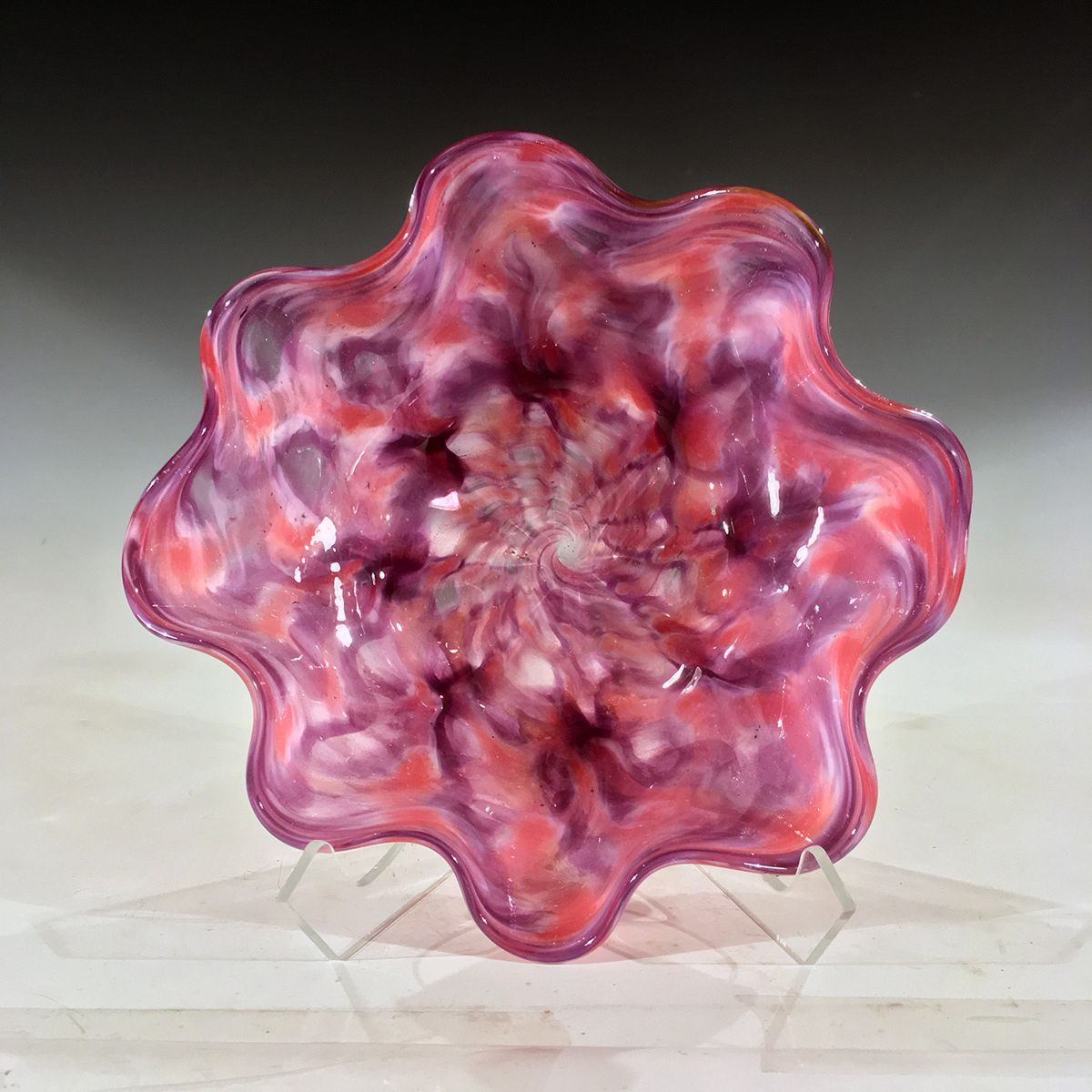 A pink and purple flower shaped bowl on a stand