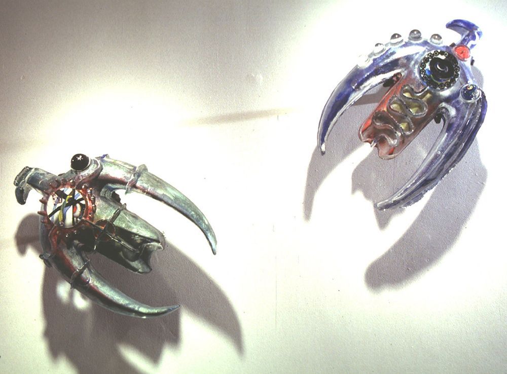 Two toy robots are sitting next to each other on a white surface