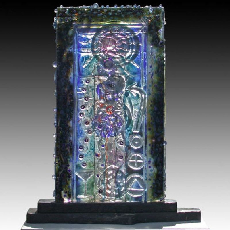 A glass sculpture with a purple and green design on it