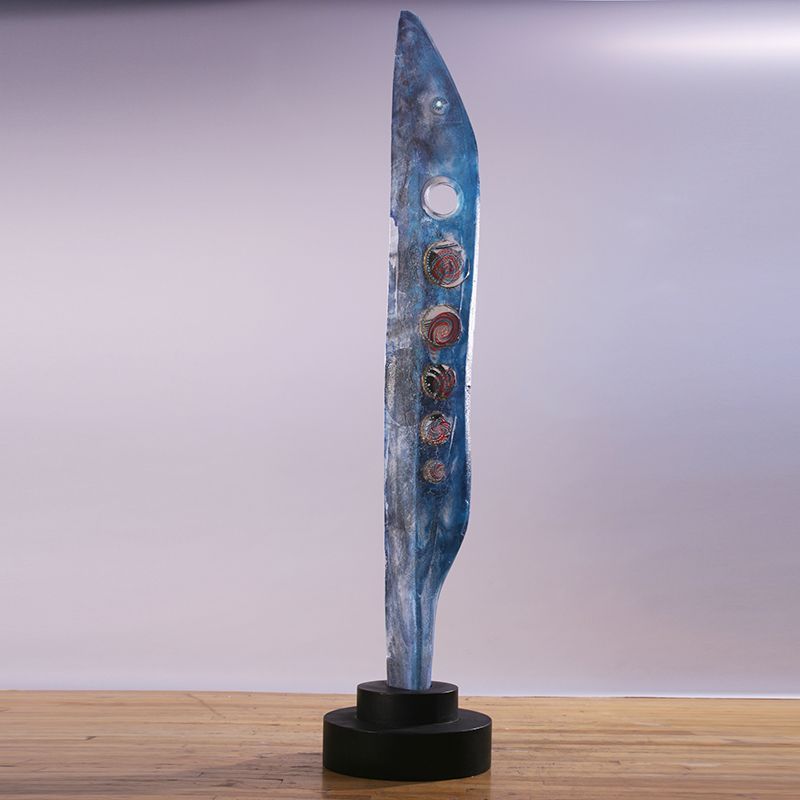 A blue sculpture is sitting on a wooden table