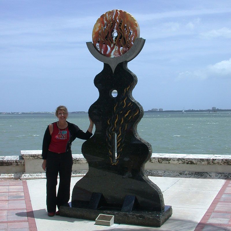 A woman stands in front of a statue that says ' freedom ' on it