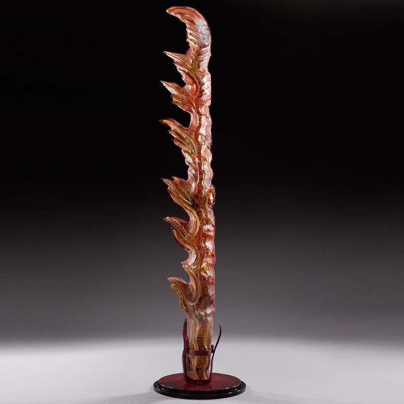 A tall sculpture of a tree with flames coming out of it