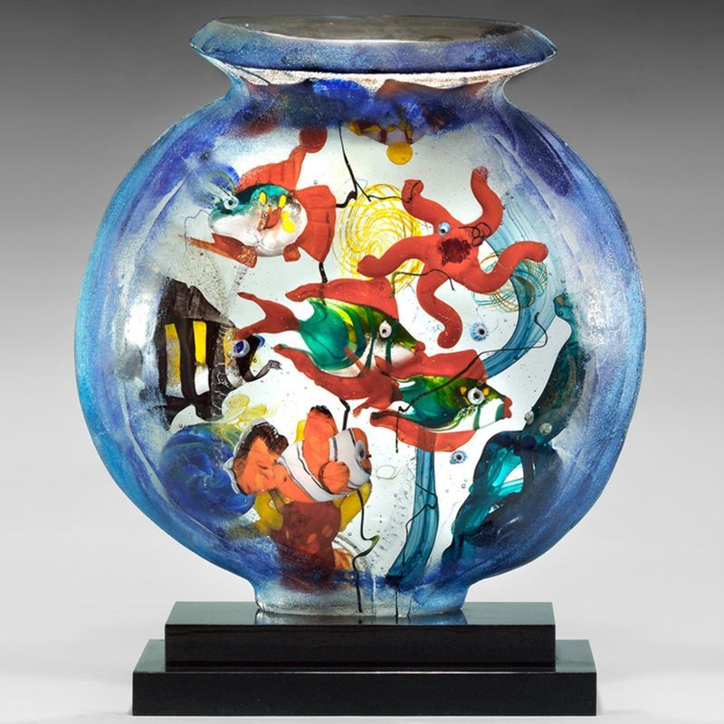 A blue vase with fish and corals inside of it