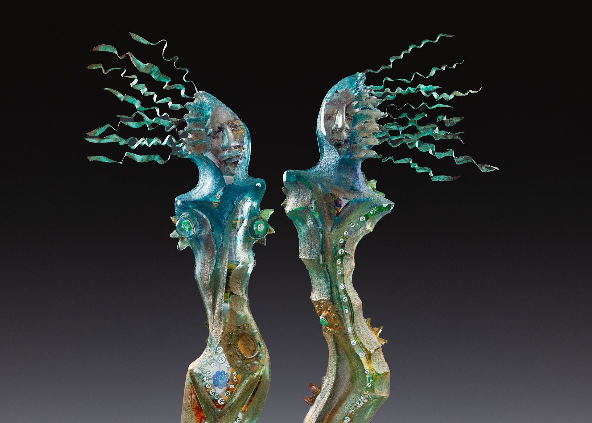 A statue of two people standing next to each other on a black background.