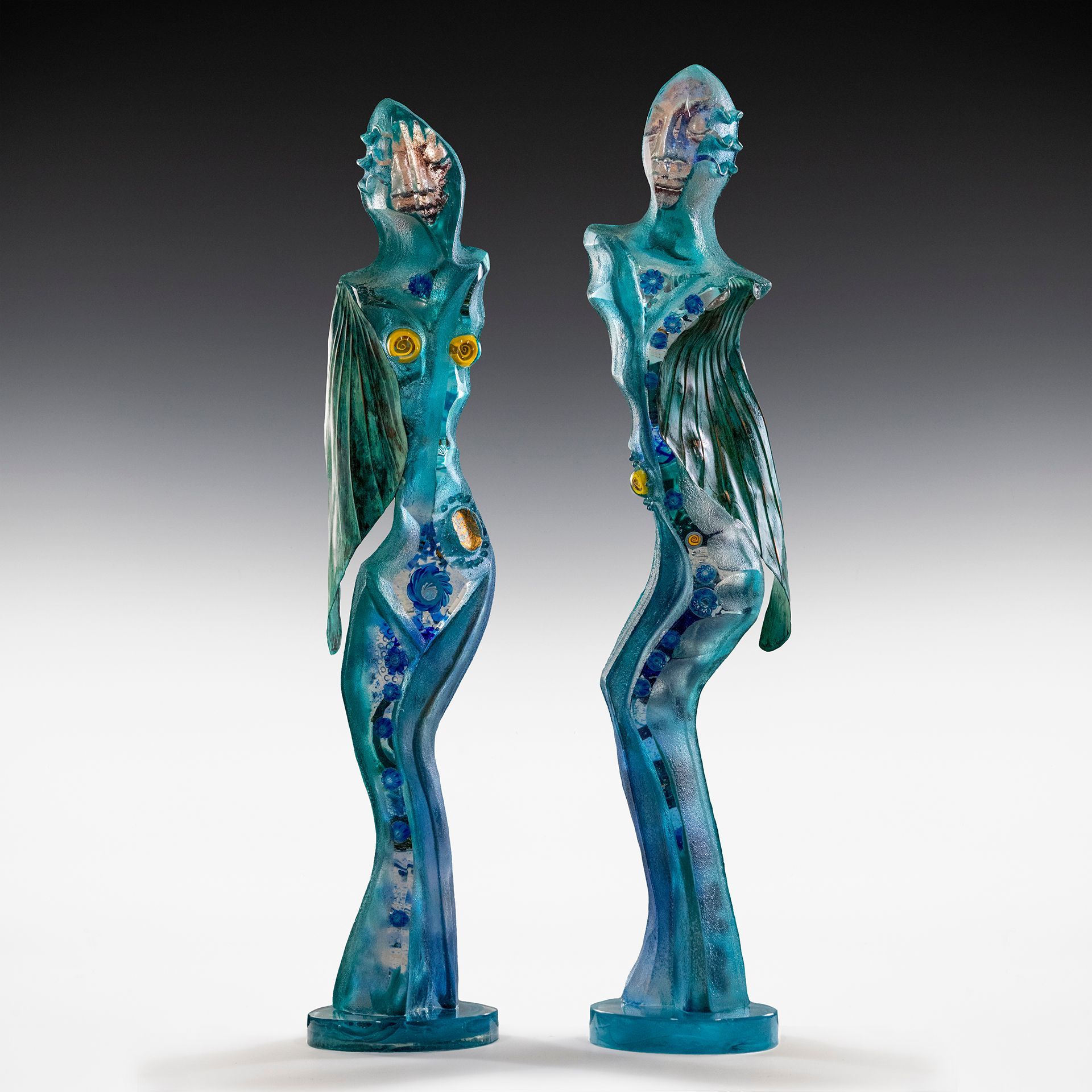 Two blue statues of a woman standing next to each other