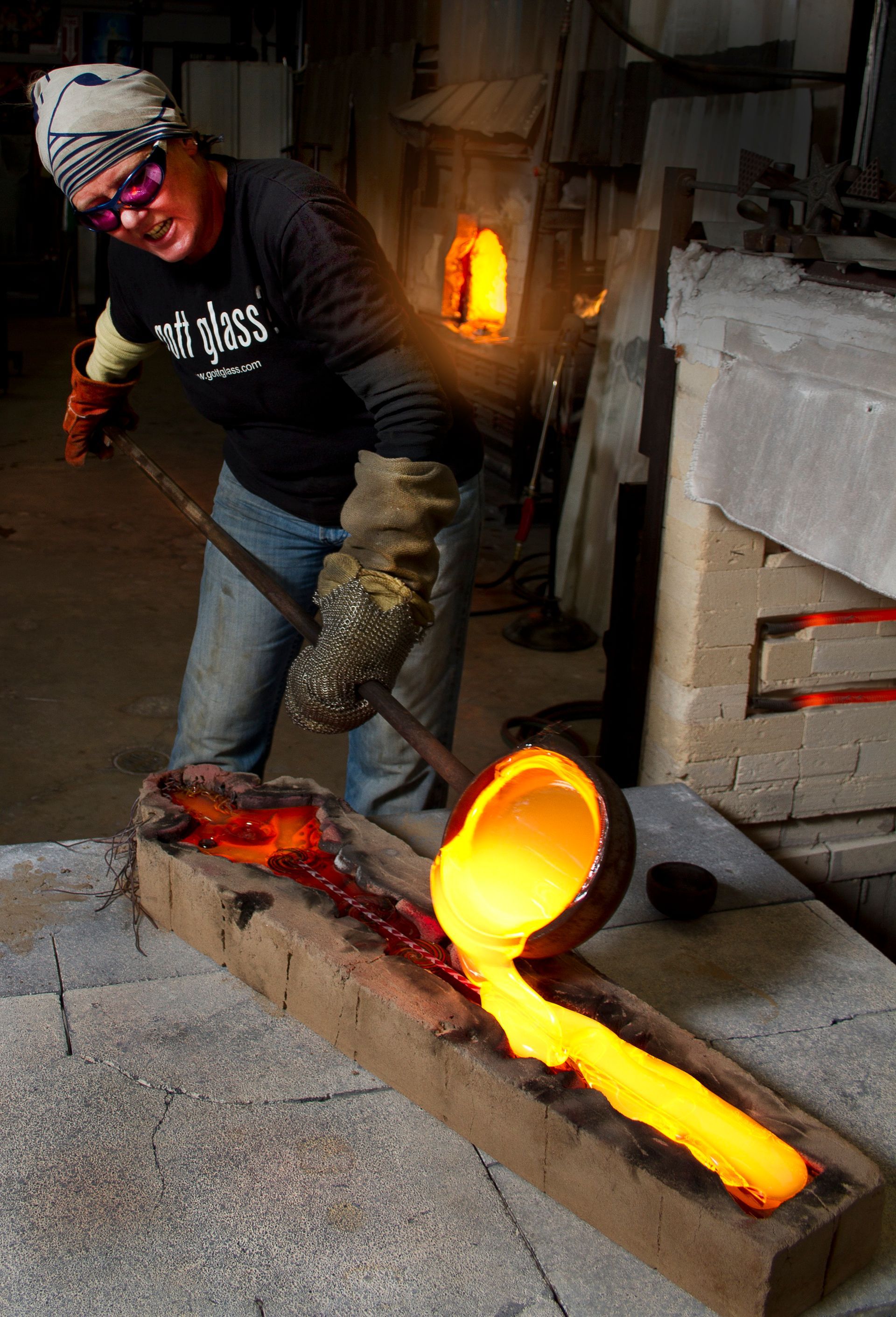 A man is pouring molten metal into a mold.