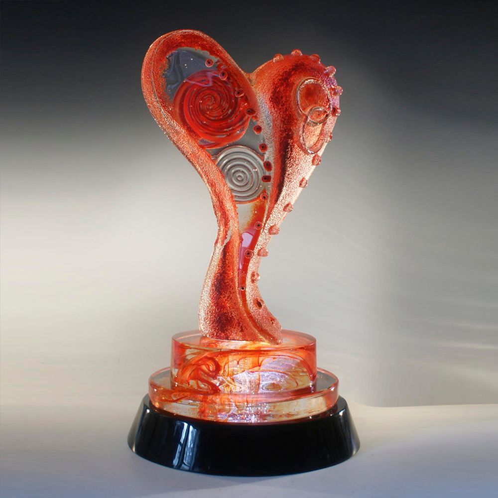 A red heart shaped sculpture on a black base