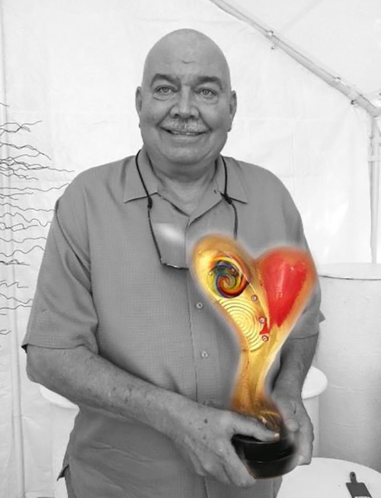 A bald man is holding a heart shaped trophy