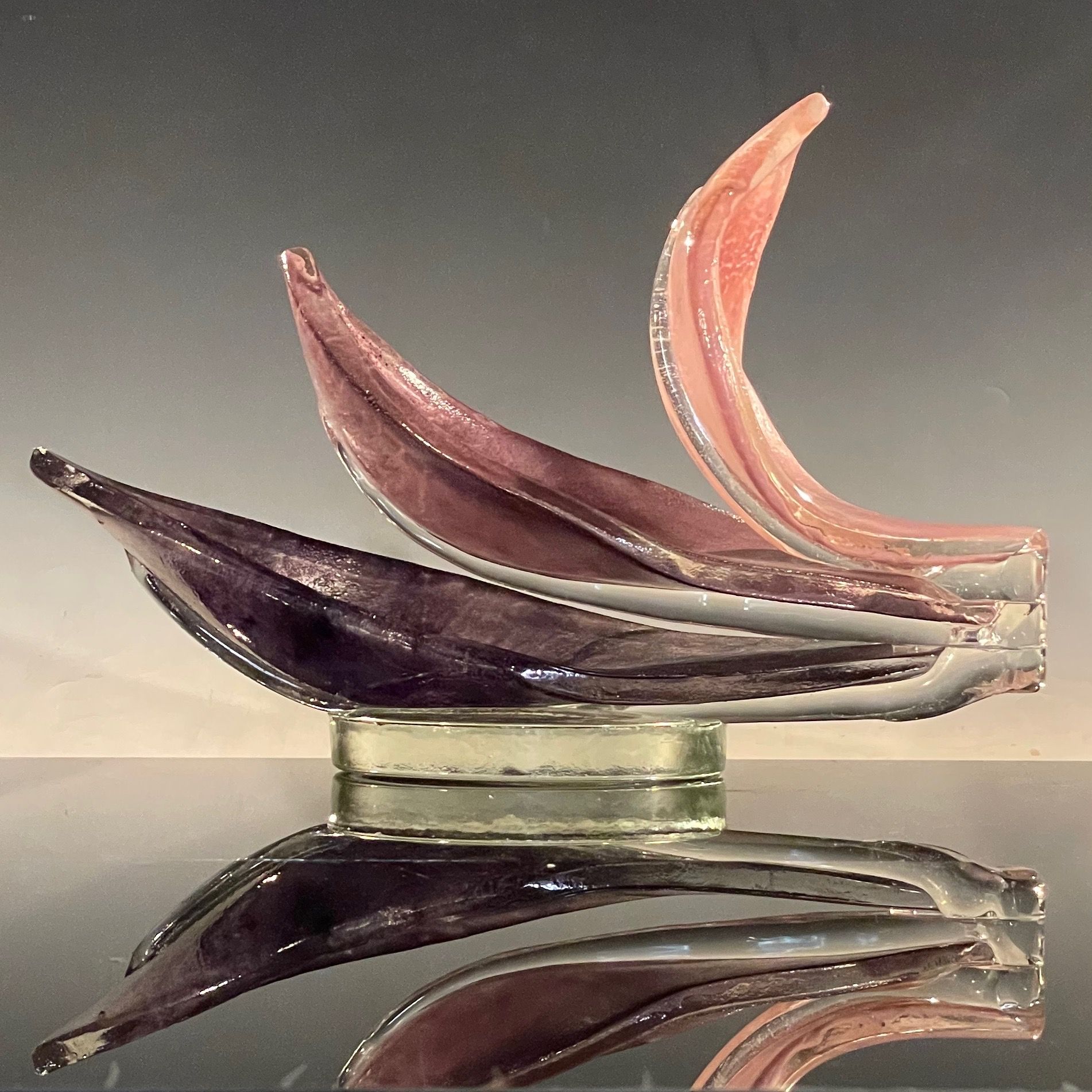 A glass sculpture of a boat is sitting on a table