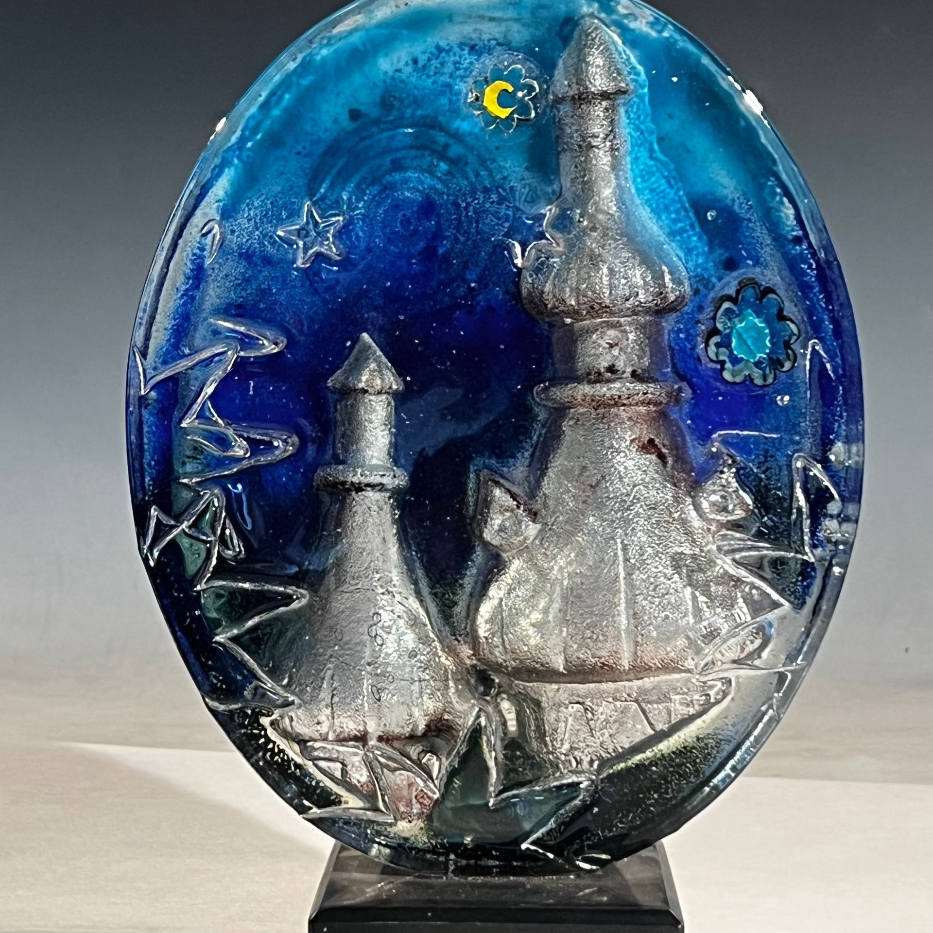 A blue glass sculpture with a castle on it