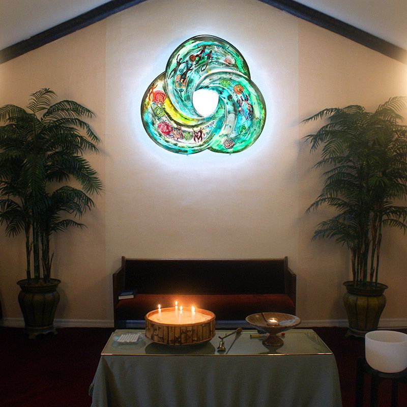 A table with a candle on it in front of a stained glass window