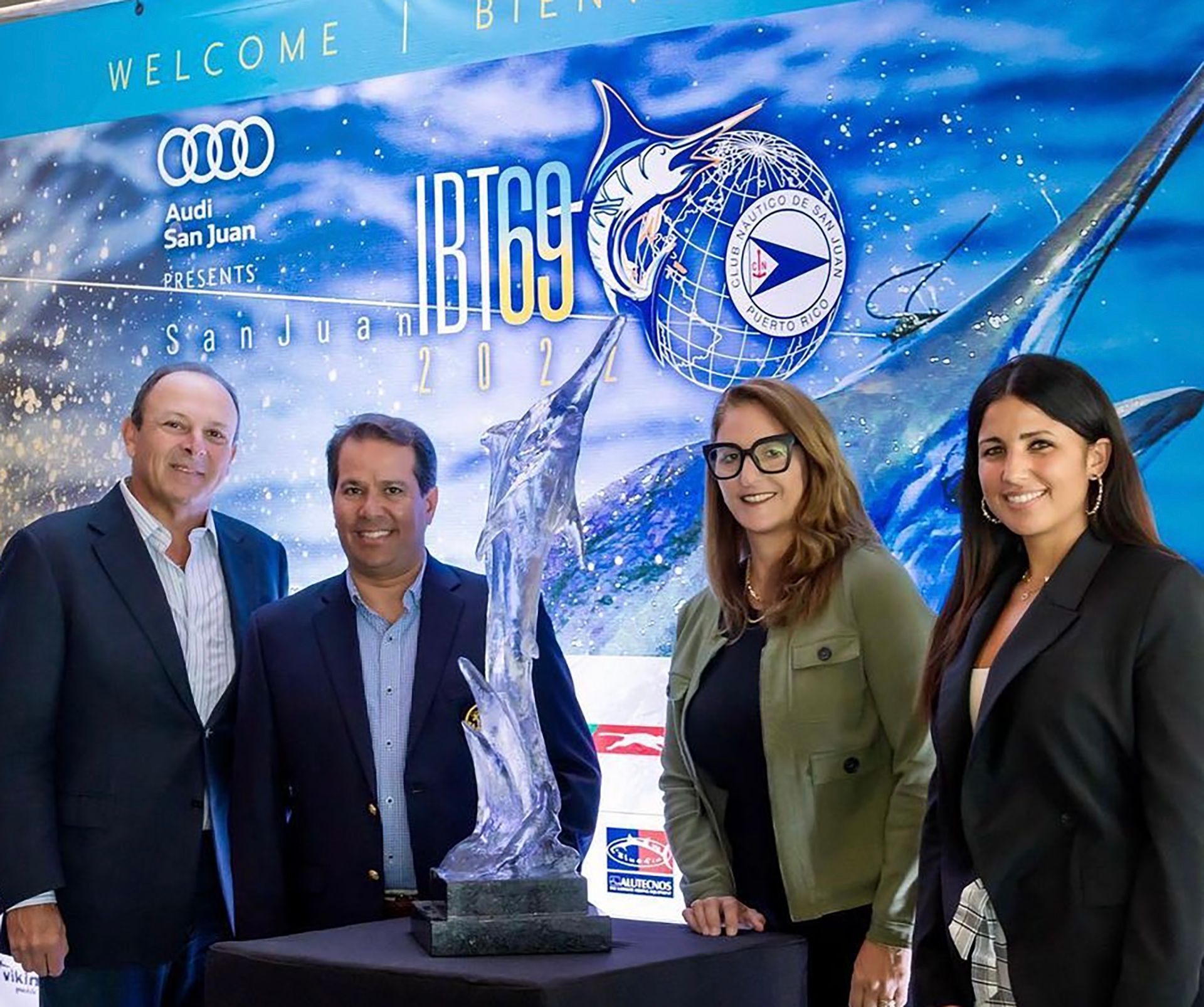 A group of people standing in front of a sign that says welcome