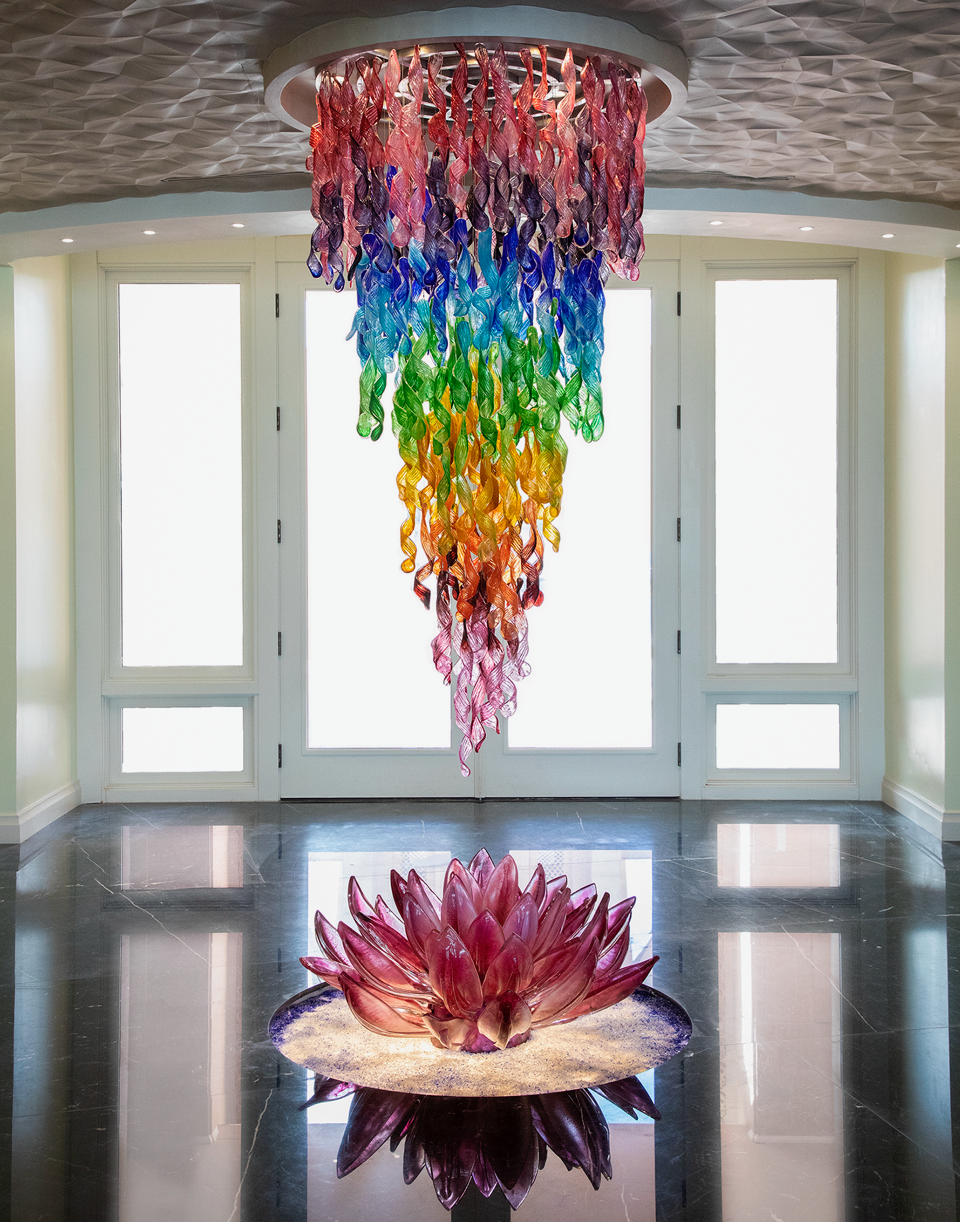 A rainbow colored chandelier is hanging from the ceiling in a room.
