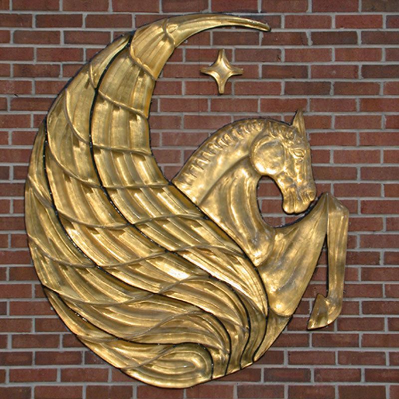 A statue of a horse with wings on a brick wall