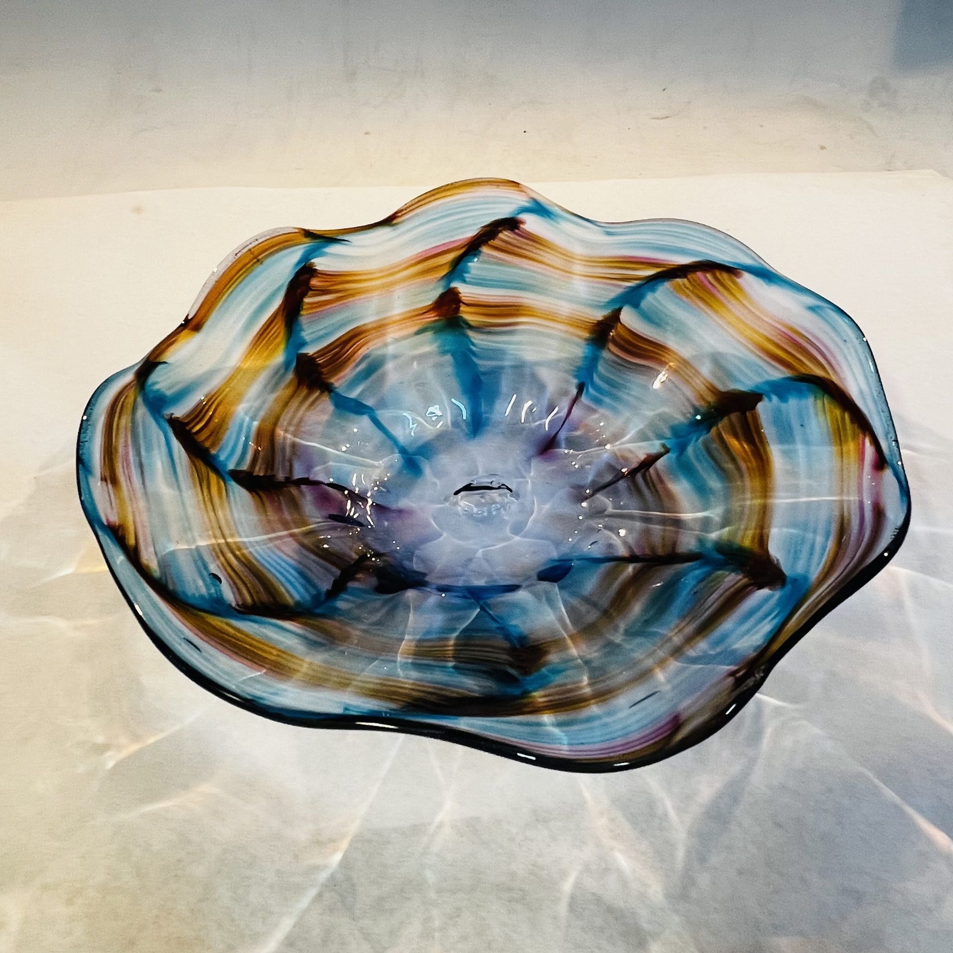 A blue and brown glass bowl is sitting on a table