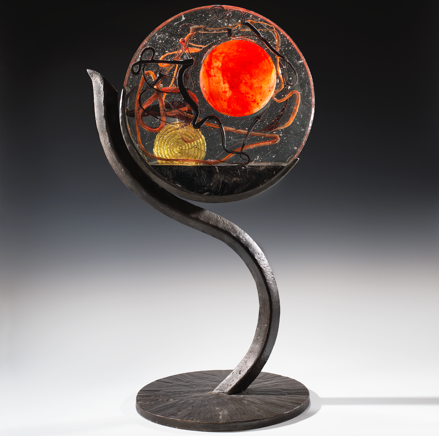 A circular sculpture with a red circle in the middle