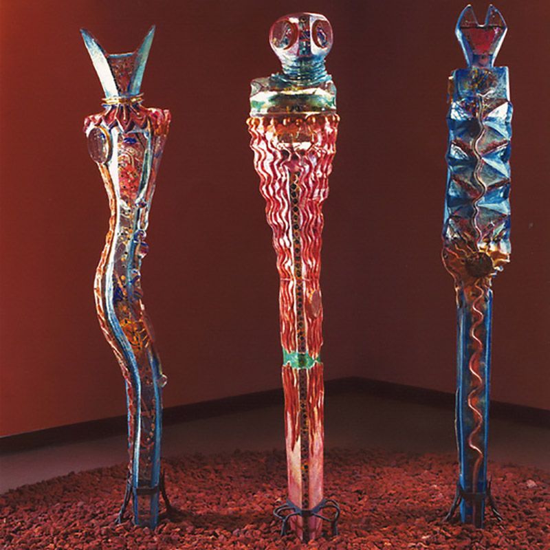 Three colorful sculptures are lined up in a room