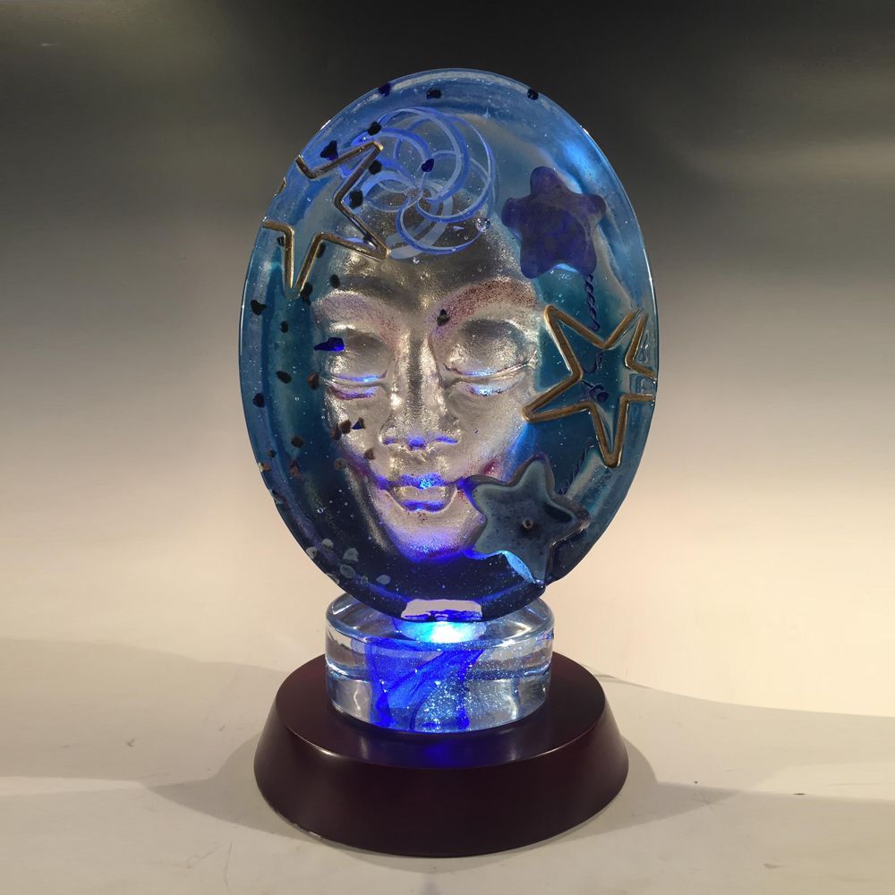 A blue glass sculpture with a face on it