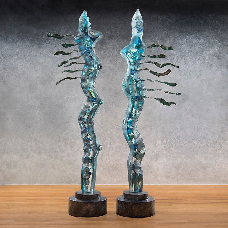 Two blue sculptures are sitting on a wooden table.