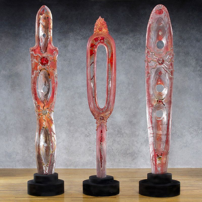 Three glass sculptures are sitting on a wooden table