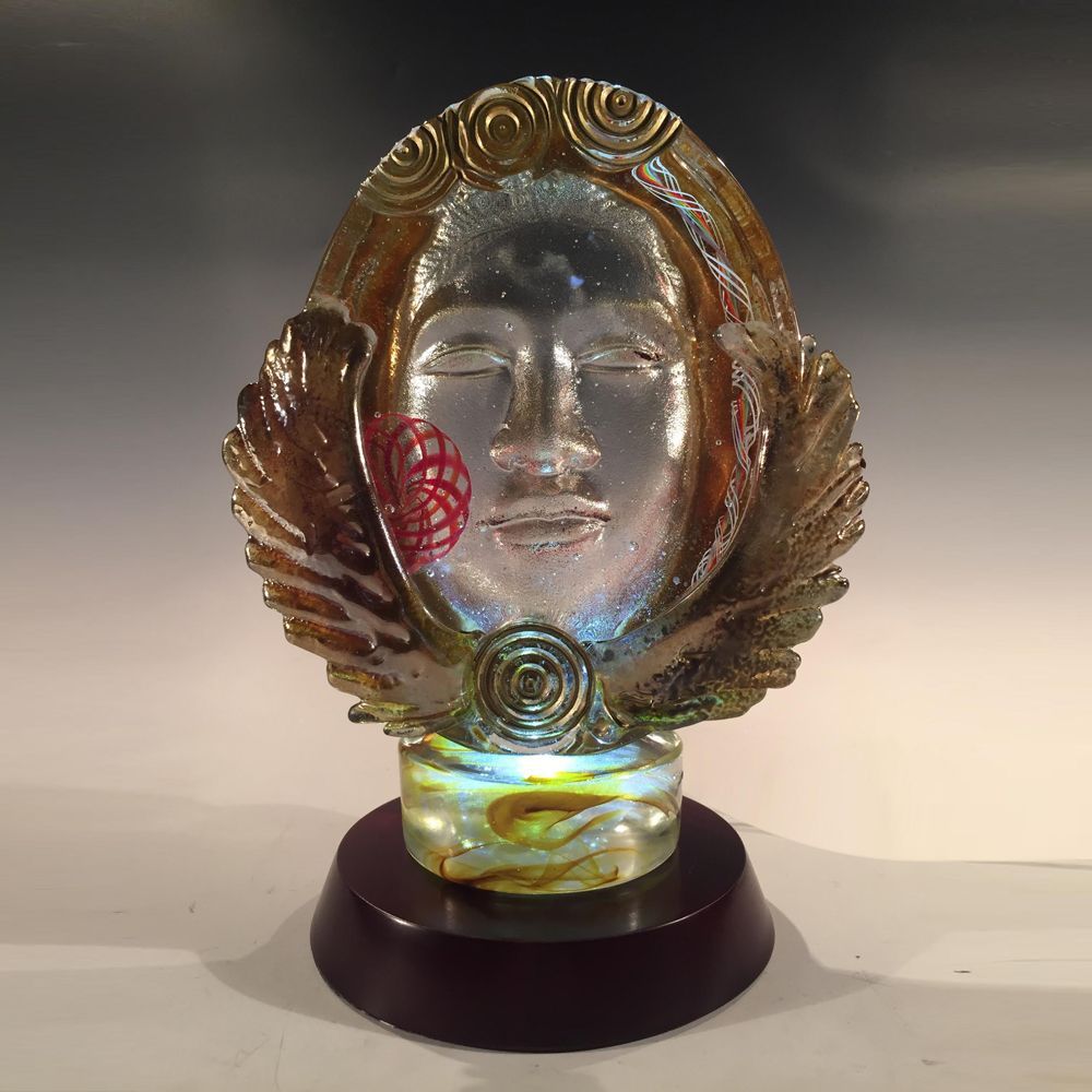 A glass sculpture of a woman 's face with her eyes closed