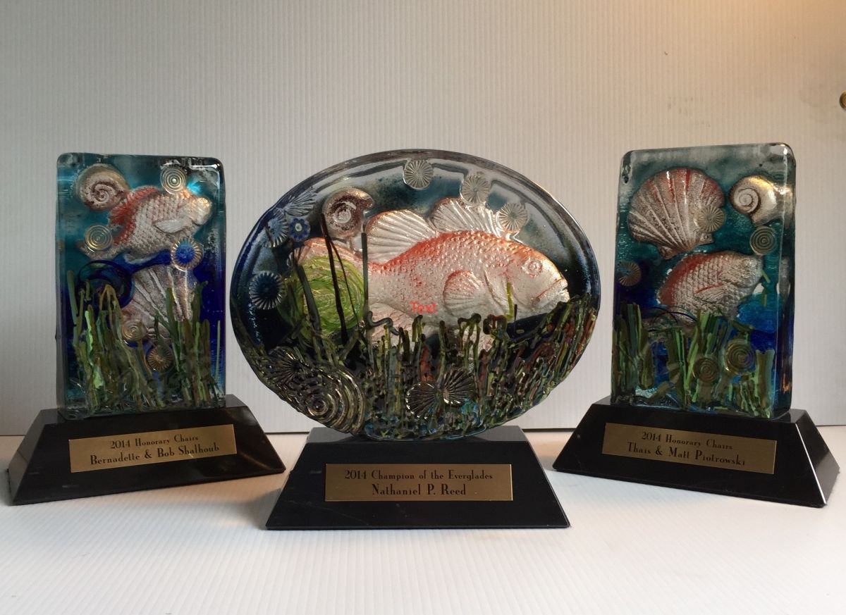 Three glass sculptures of fish are sitting on a table