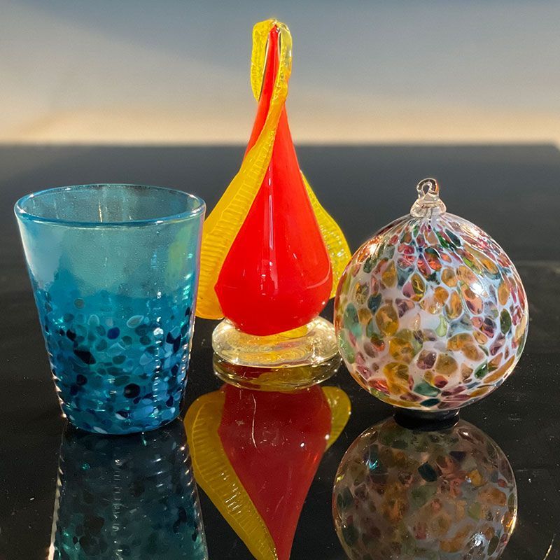 Three colorful glass objects are sitting on a table