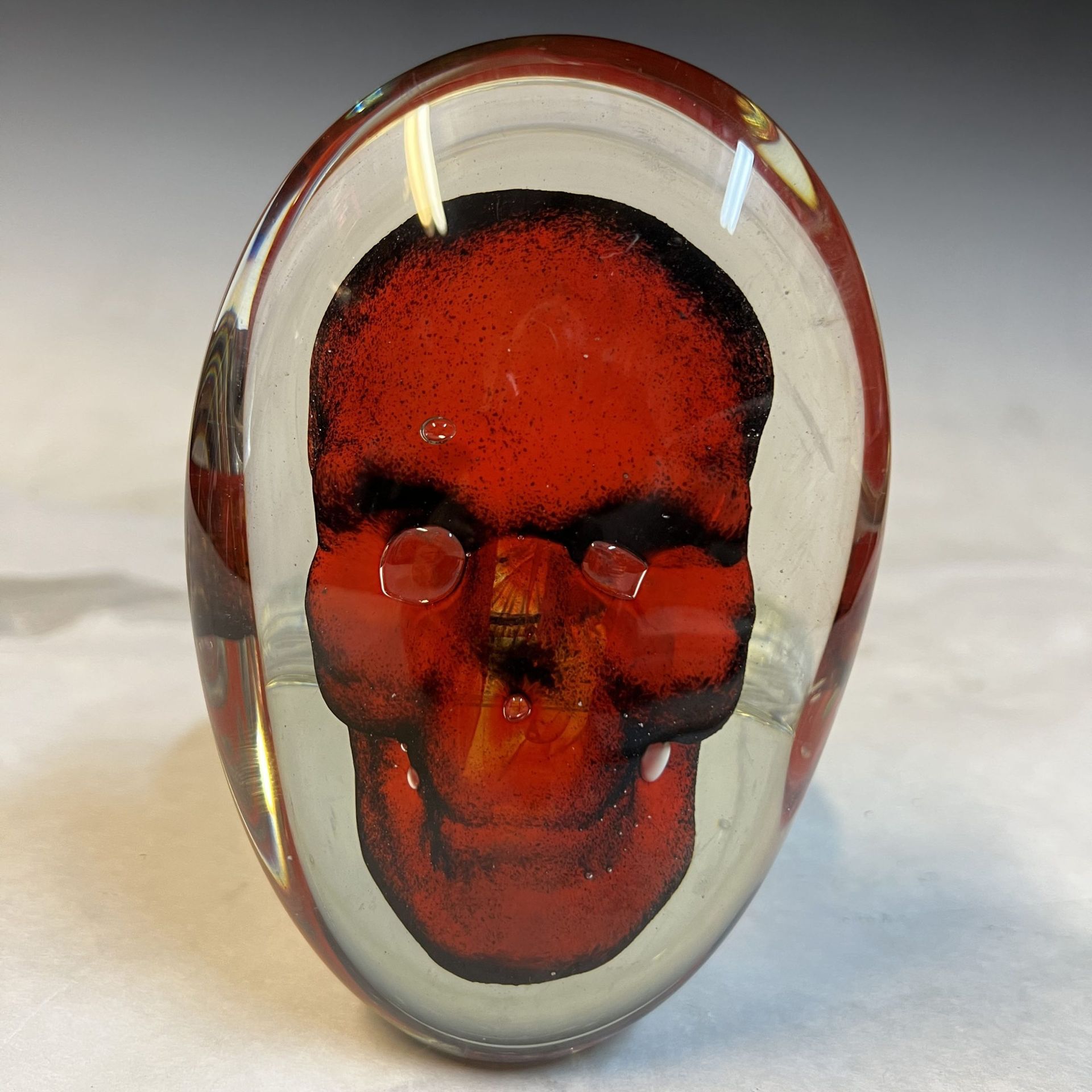 A glass ring with a red skull on it