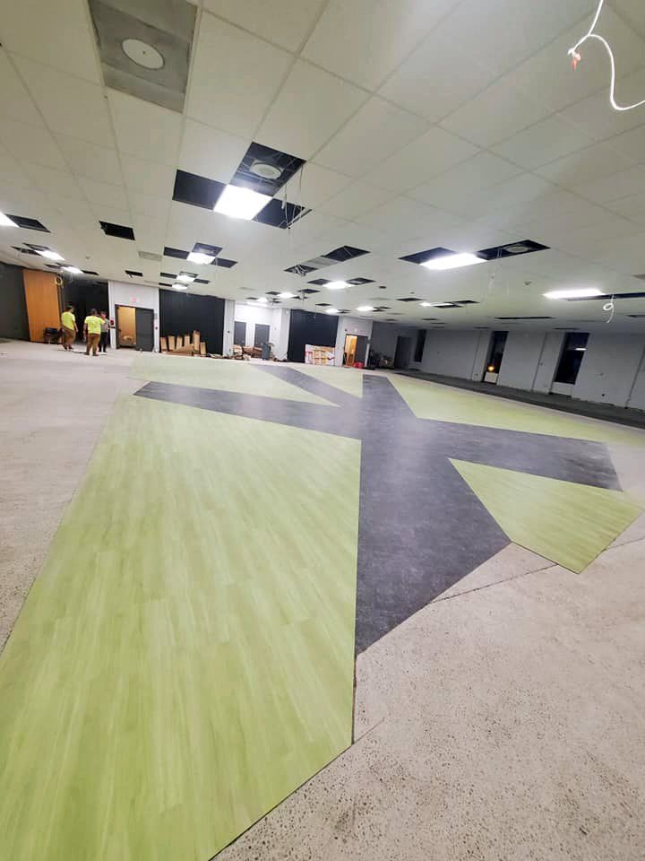 Commercial flooring installation is nearly complete in this school auditorium.