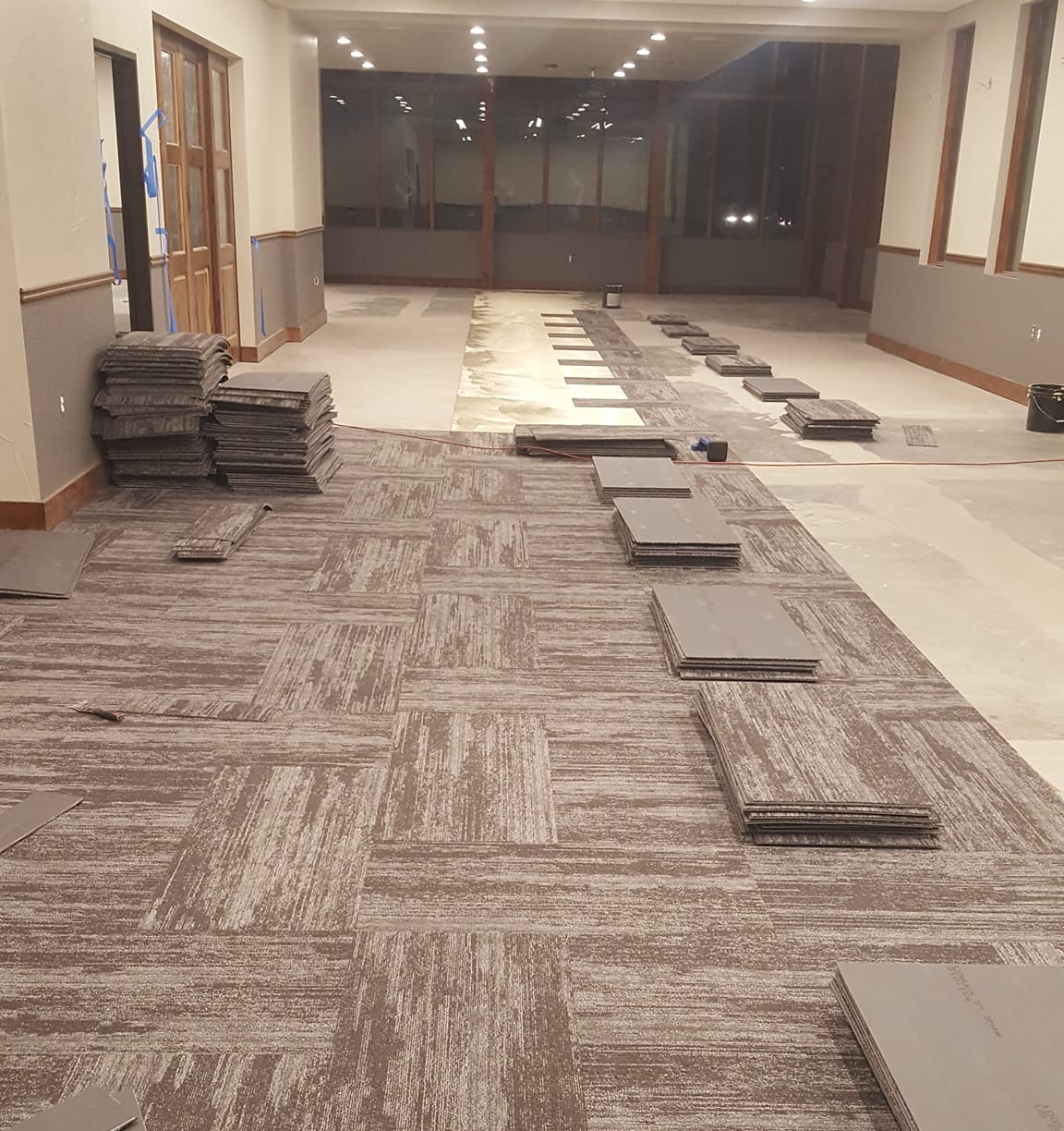Carpet tiles are being installed in this large commercial space.