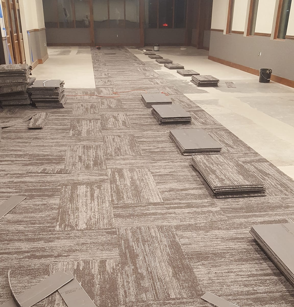 Progress is being made on the installation of these carpet tiles in this commercial space.