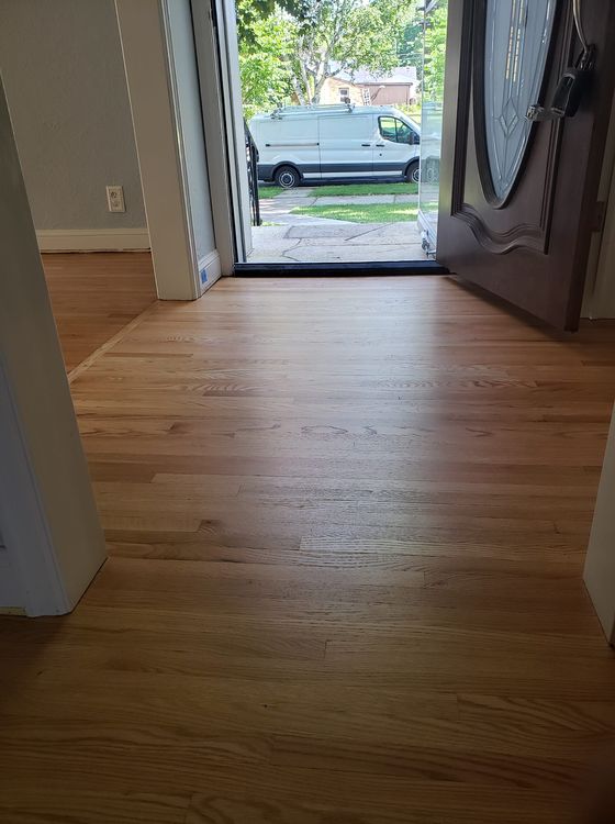 Refinished hardwood floors have been improved since being poorly restored.