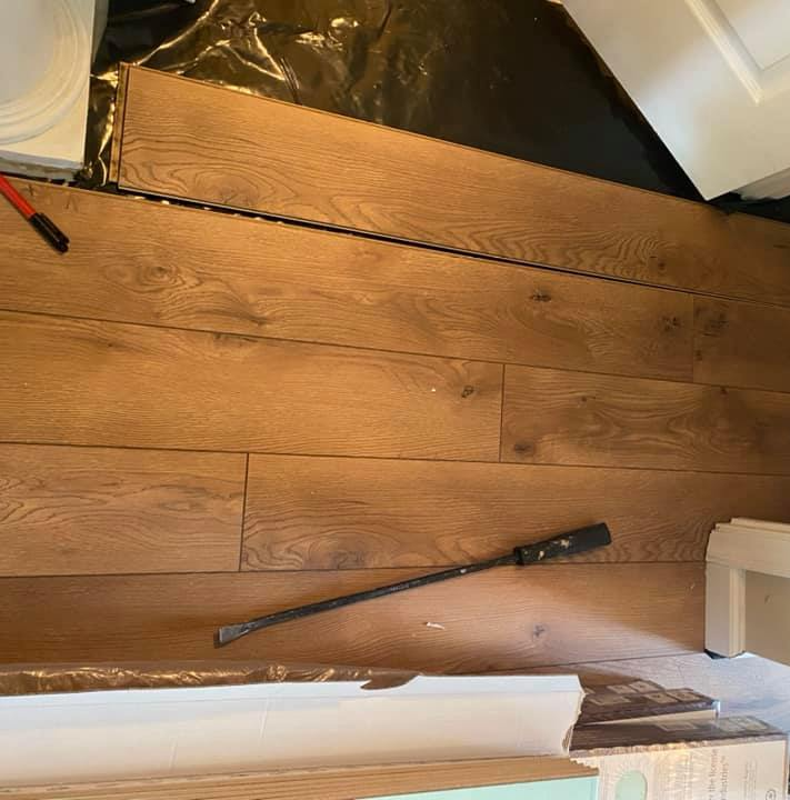 A progress photo of solid wood flooring being installed in a home hallway.