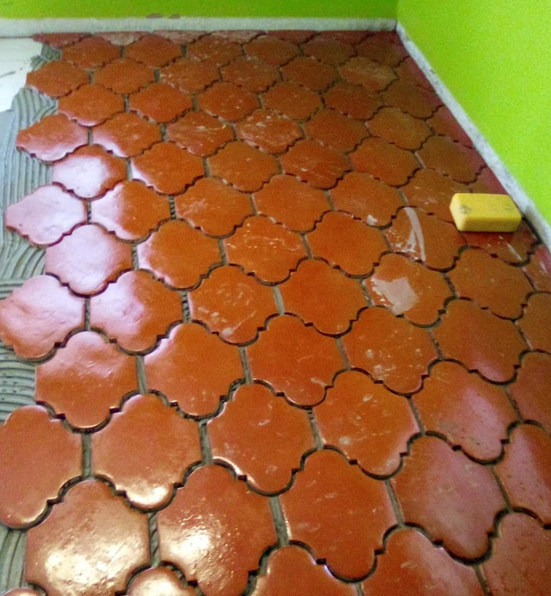 A traditional ceramic tile floor is being installed in this small Portuguese restaurant.